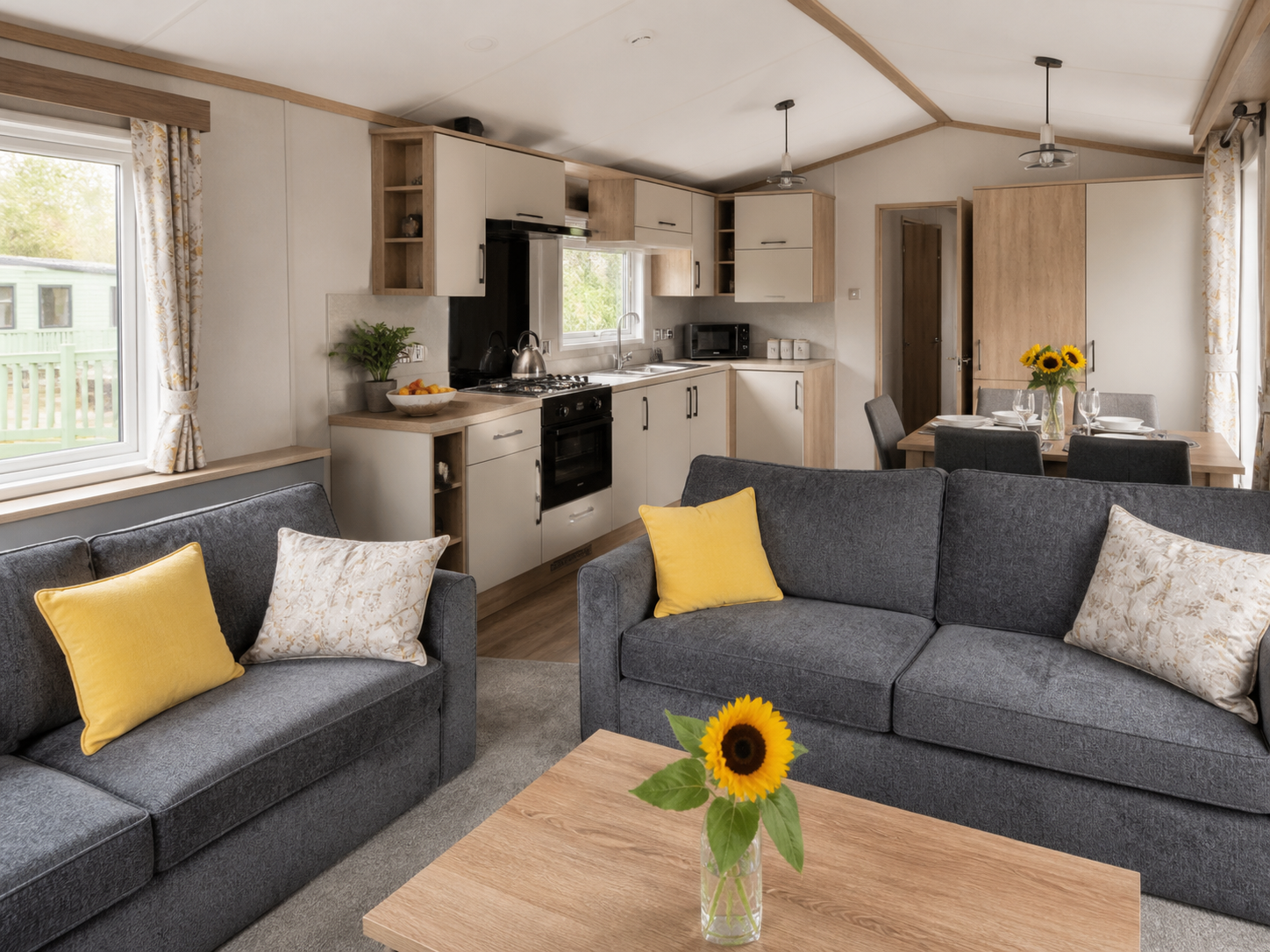 Immaculately cleaned holiday caravan lounge and kitchen with charcoal furnishings.